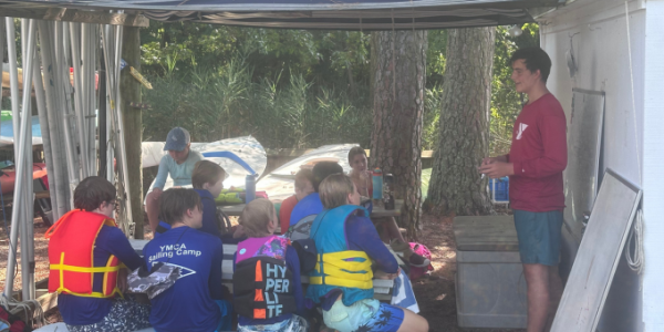 teen coaching a group of children outside