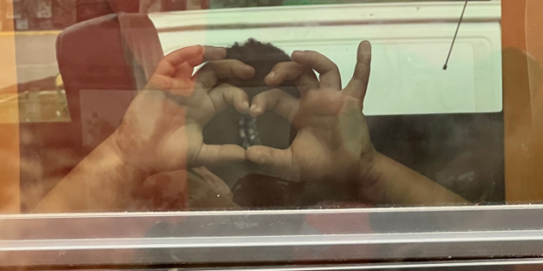 boy making a shape of a heart with his hands