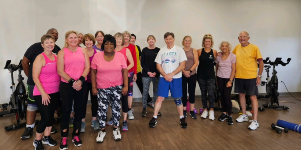 a group of women and men in an exercise class.