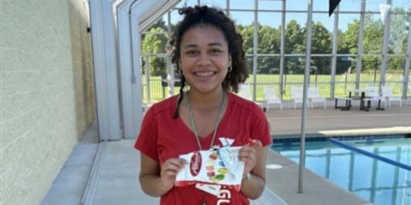 a young lifeguard girl holding a bag of gummy bears.