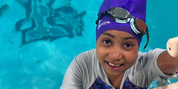 a young swimmer in the pool with a cap on