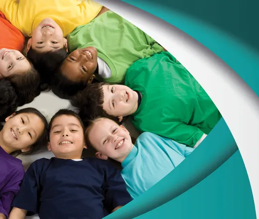 group of children laying down in a circle looking at the camera