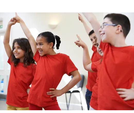 5 kids in red shirts dancing in a white room