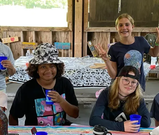 Kids in large cabin drinking out of a plastic cup
