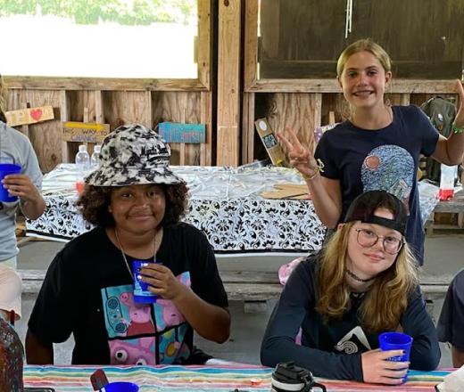 Kids in large cabin drinking out of a plastic cup