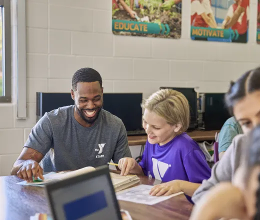 Volunteer helping child with homework.