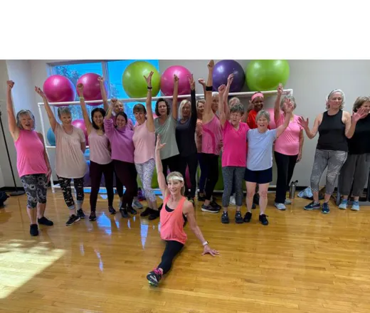 Group class holding hands up in celebration