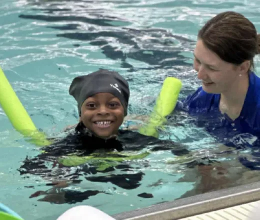 swim instructor swimming with a child