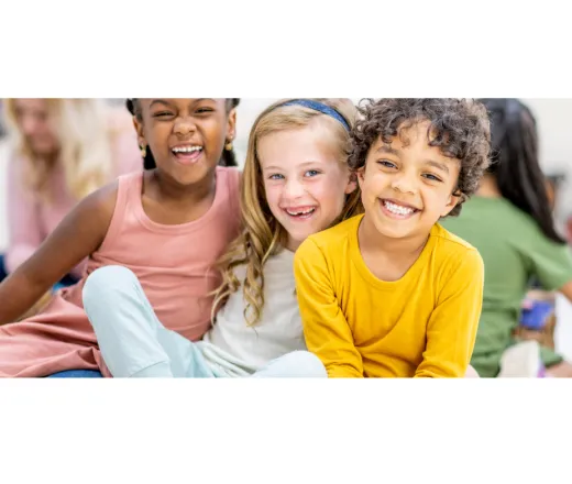 four children sitting down smiling at the camera