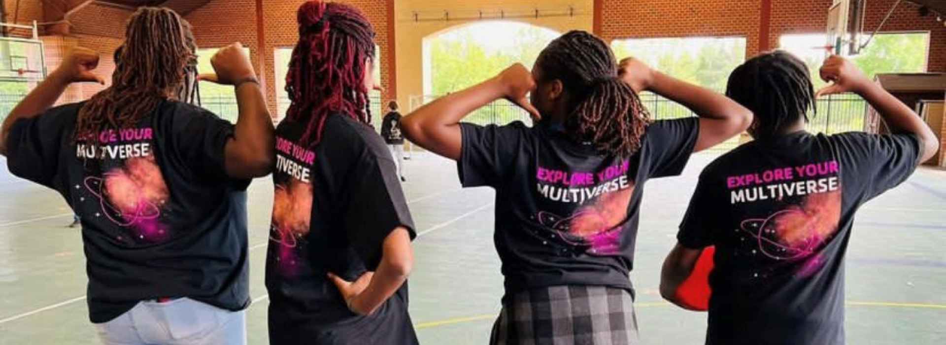 Y Achievers pointing at their club shirts.