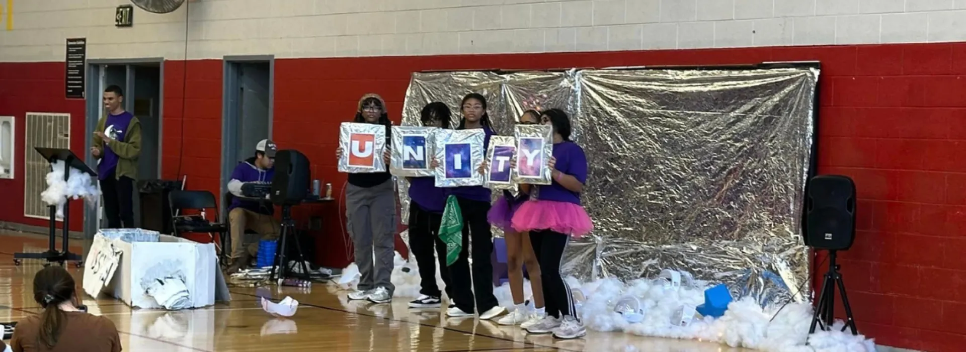 Leaders club teens holding a sign that says unity
